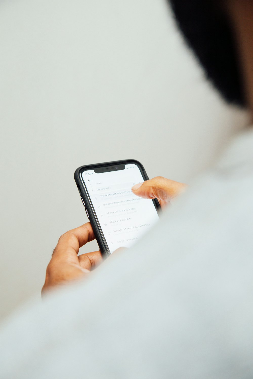 明るい部屋で、スマホのメッセージを読んでいる手元